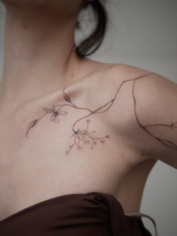 Floral design tattooed on the shoulder, done in illustrative style.