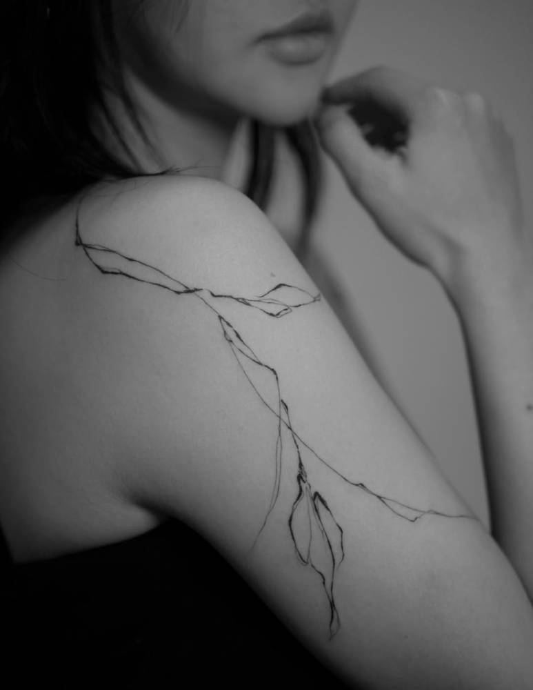 Leaves tattoo located on the upper arm and shoulder.
