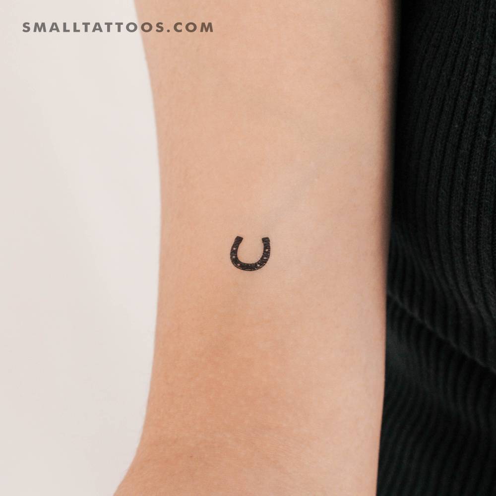 Tiny horseshoe temporary tattoo located on the bicep.