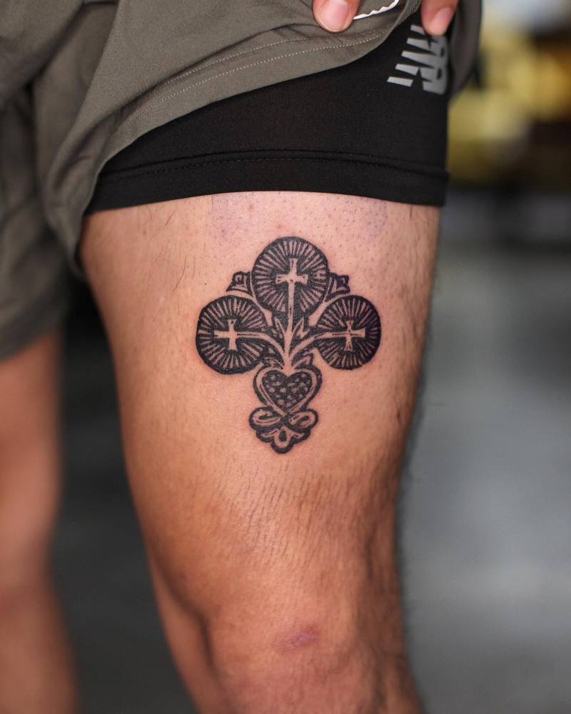 Sacred heart and crosses tattoo located on the thigh.