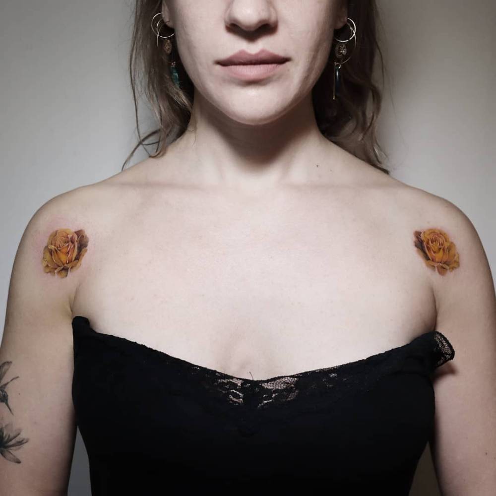 Individual matching yellow rose tattoos located on the shoulders.