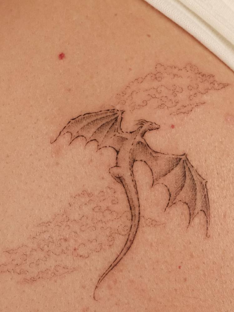 Dragon tattoo in illustrative style located on the back.