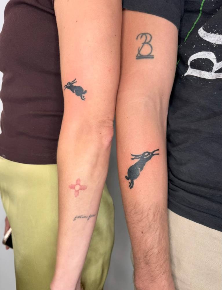 Matching hare tattoo in blackwork style for couple.