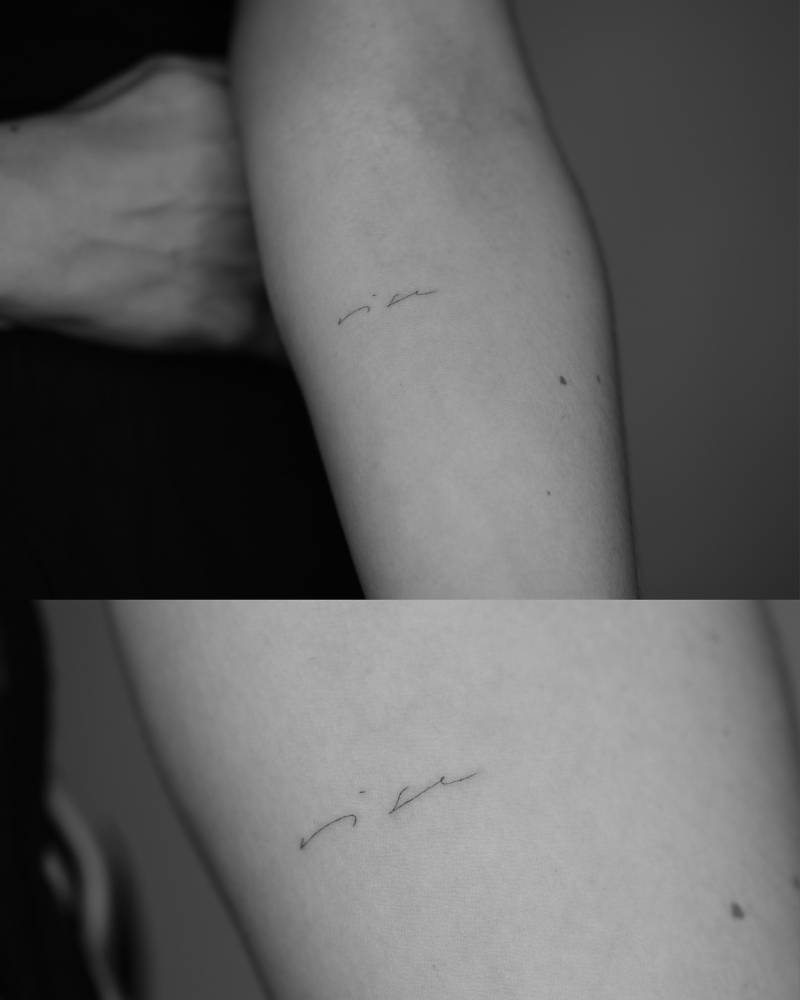 Handwritten font word "rise" tattoo located on the inner forearm.