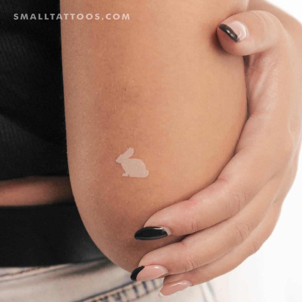 White color rabbit temporary tattoo located on the tricep.