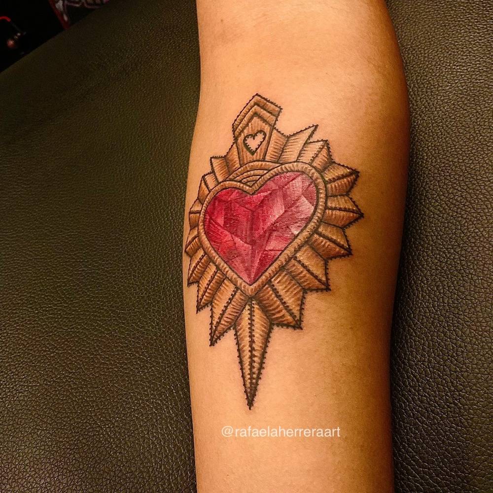 Mexican embroidery sacred heart tattooed on the inner forearm.