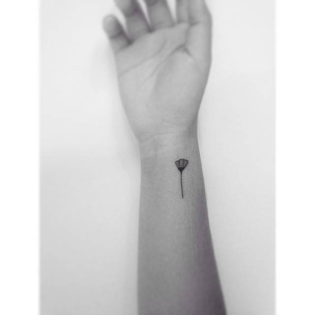 Minimalistic flower tattoo located on the wrist.