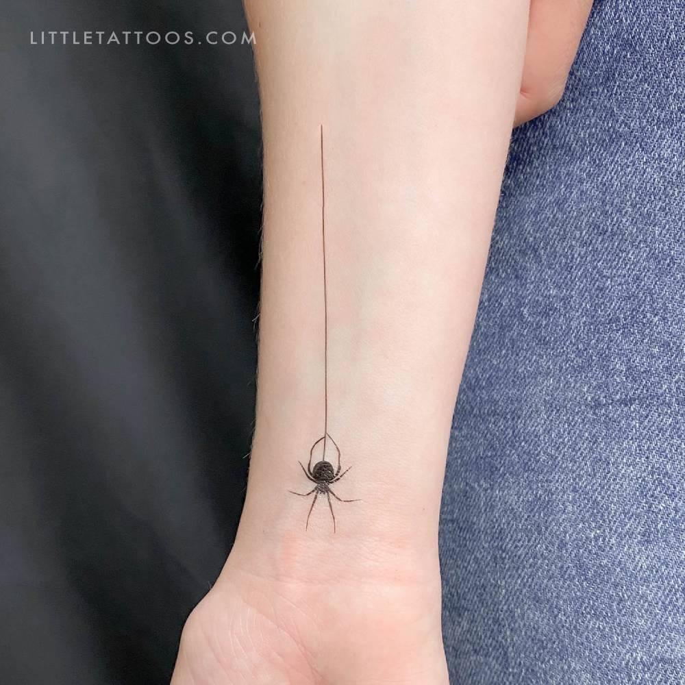 Hanging spider temporary tattoo located on the wrist.