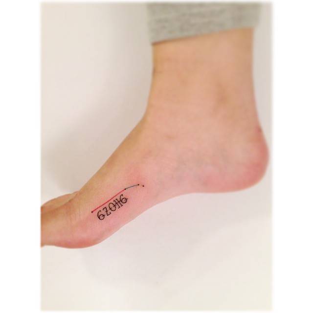 Aries constellation and numbers tattooed on the foot, minimalistic style.