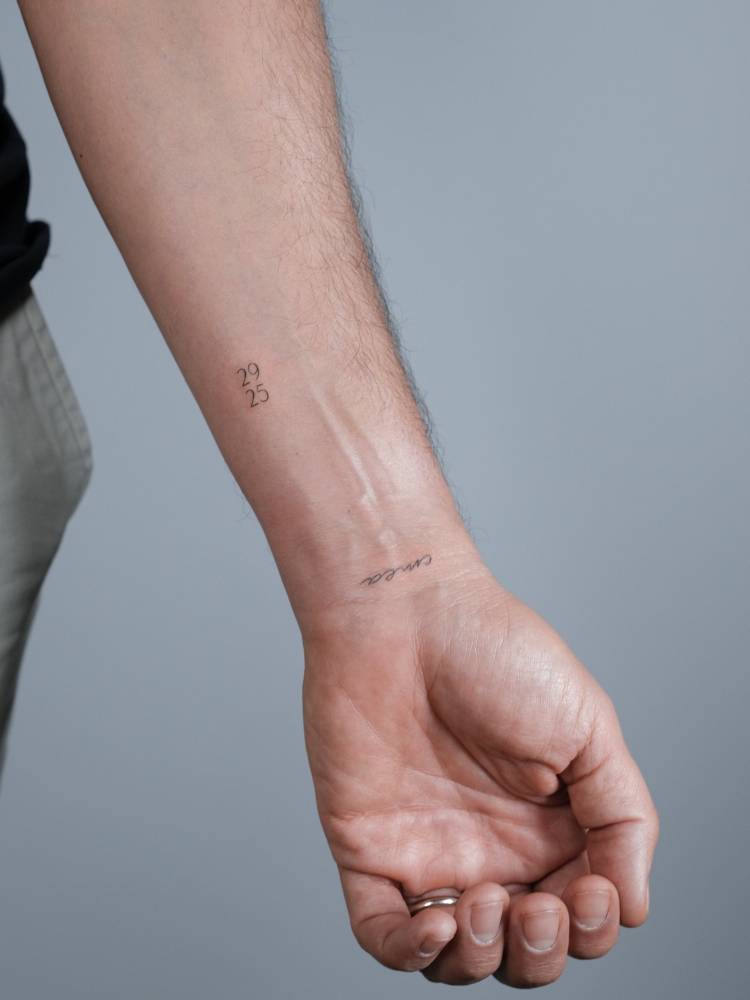 Numbers "29" and "25" tattoo located on the wrist.