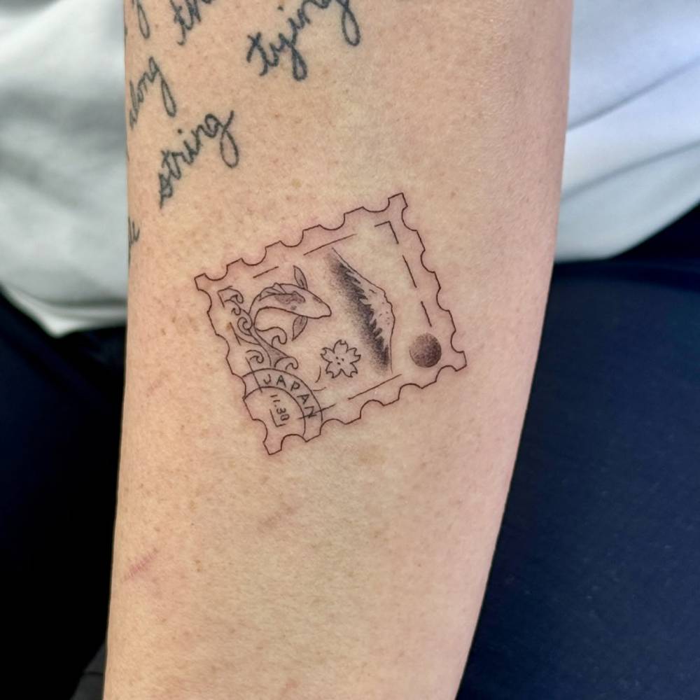 Japanese stamp tattoo in illustrative style located on the forearm.