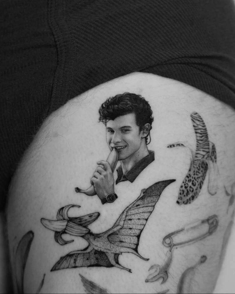 Micro-realistic style Shawn Mendes portrait tattoo located on the thigh.