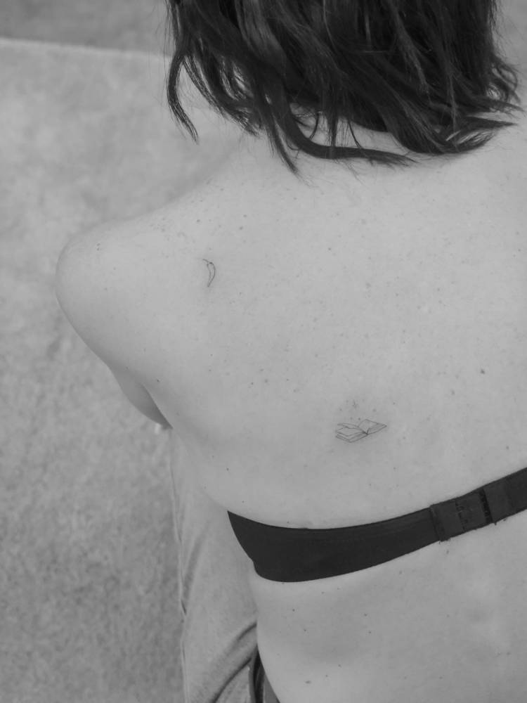 Little chili pepper and book tattoos located on the shoulder blade and back.