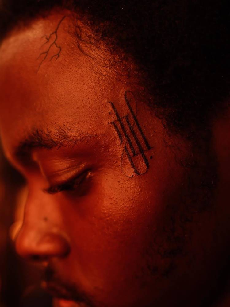 Monogram tattoo located on the face.