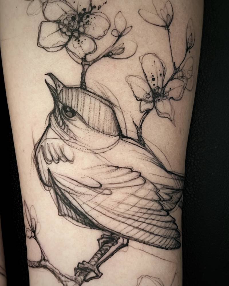 Sketch work style bird on a branch tattoo located on the inner forearm.