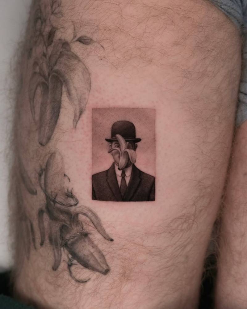 'Man in a Bowler Hat' and banana tattooed on the thigh.