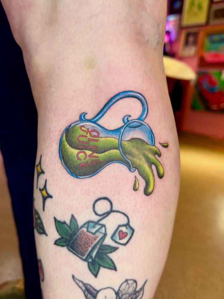 Olive oil tattoo in illustrative style located on the calf.