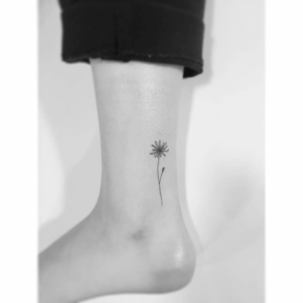 Tiny dandelion tattoo in fine line style done on the ankle.