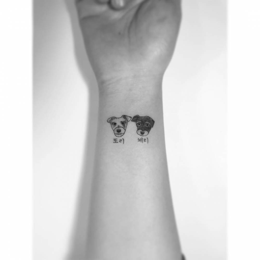 Schnauzer portraits tattooed on the wrist, illustrative style.