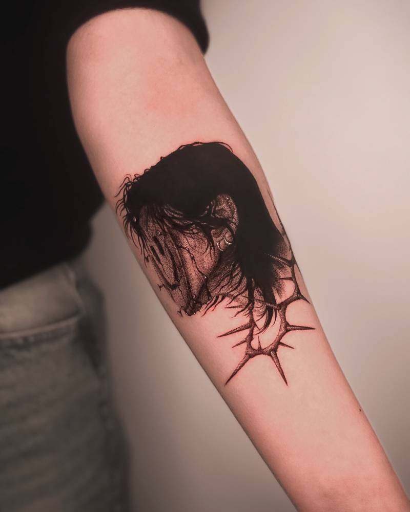 Smiley mask tattoo located on the inner forearm.
