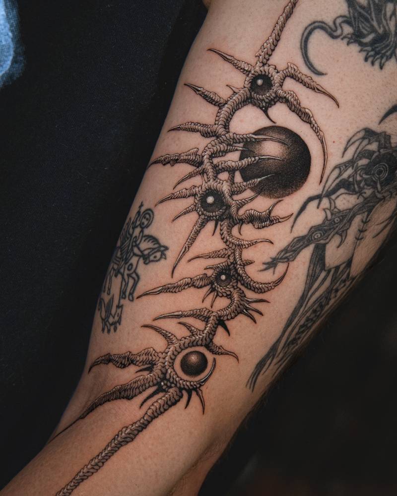 Comic style abstract thorns tattoo located on the upper arm.