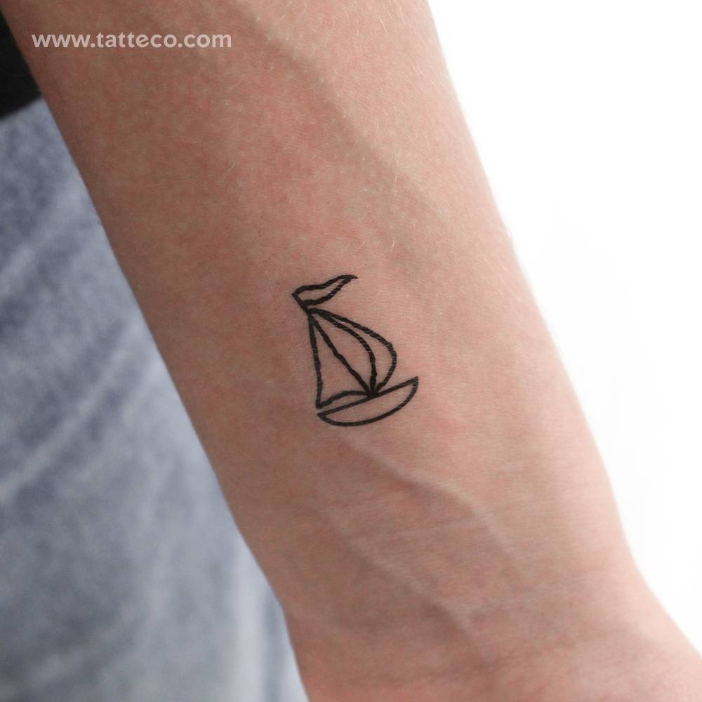 Minimalist style sailboat temporary tattoo located on the wrist.