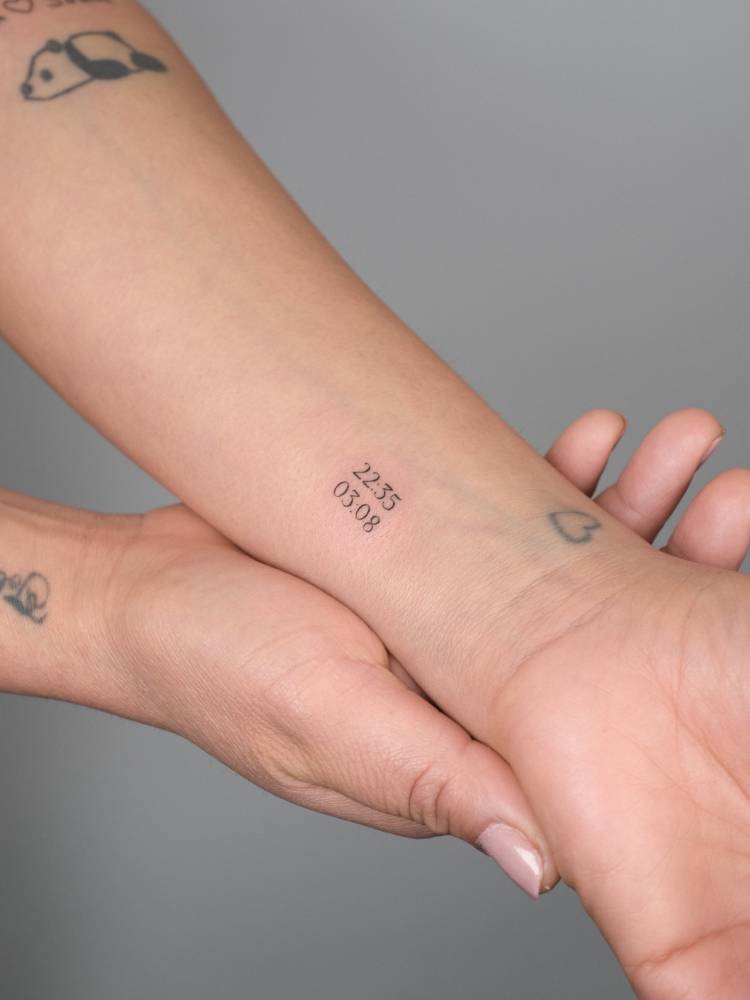 Minimalistic style hours tattoo located on the wrist.