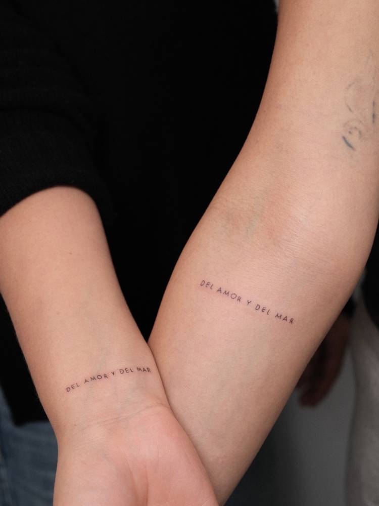 Matching "del amor y del mar" lettering tattoo for best friends.