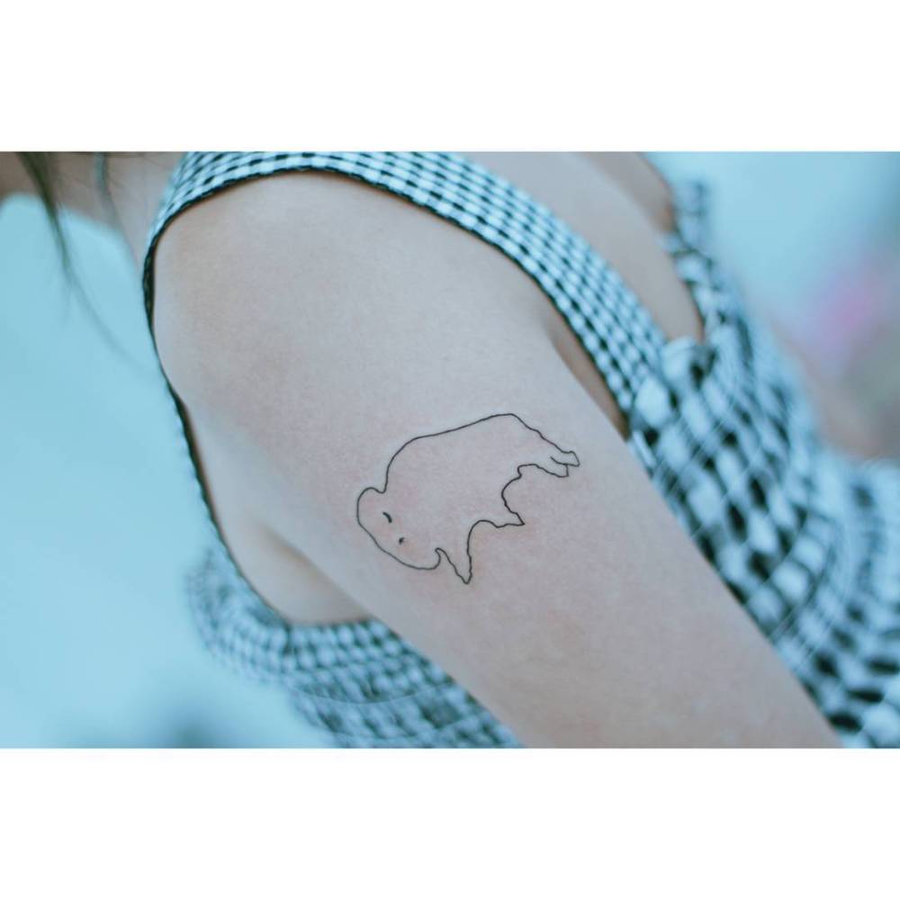 Child drawing tattoo located on the upper arm, fine line style.