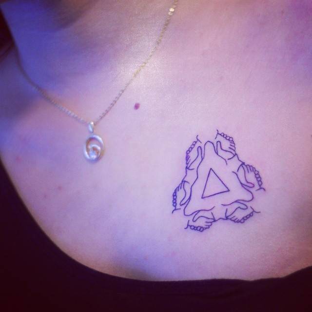 Holding hands triangle tattoo located on the chest.