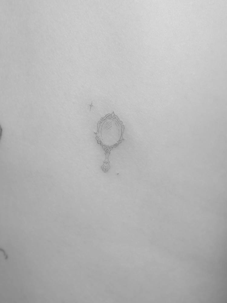 Hand mirror tattoo in fine line style done on the back.