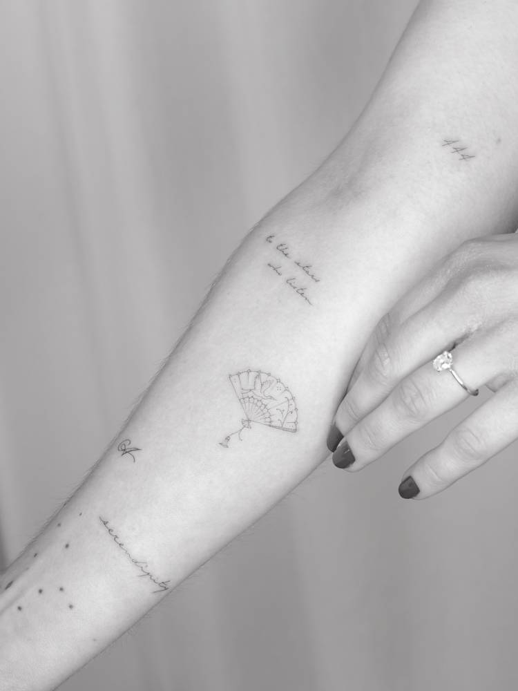 Hand fan tattoo done on the inner forearm, fine line style.