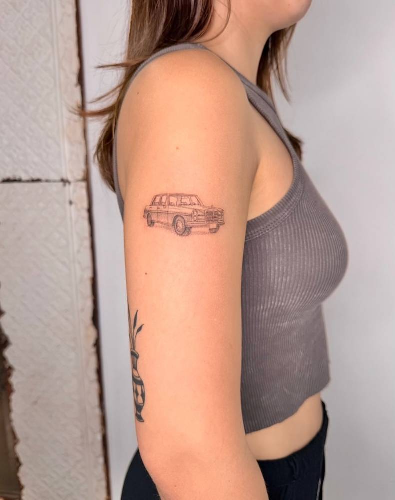 Single needle car tattoo located on the upper arm.