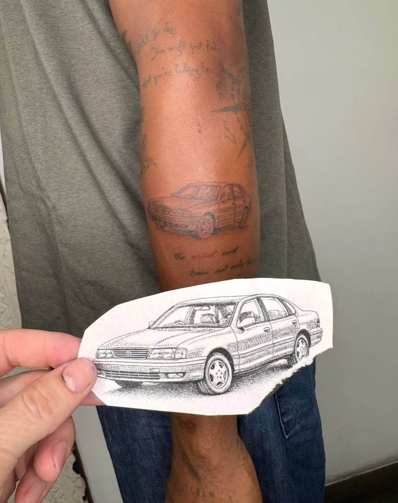 Toyota car tattooed on the forearm, illustrative style.