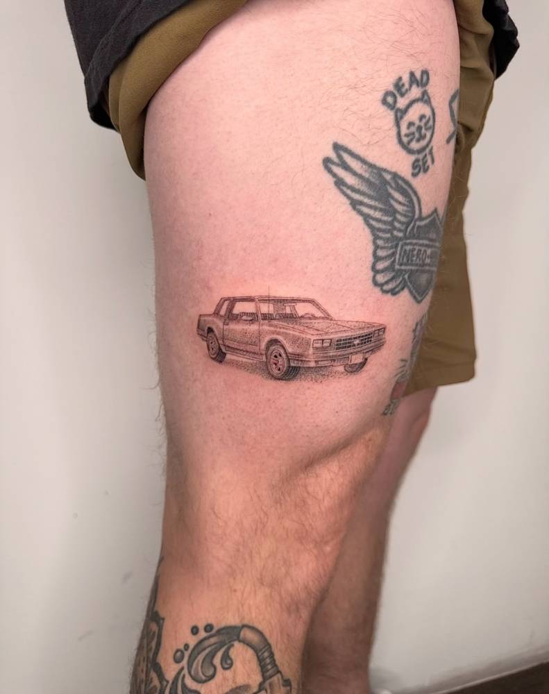 Chevrolet tattoo located on the thigh, illustrative style.