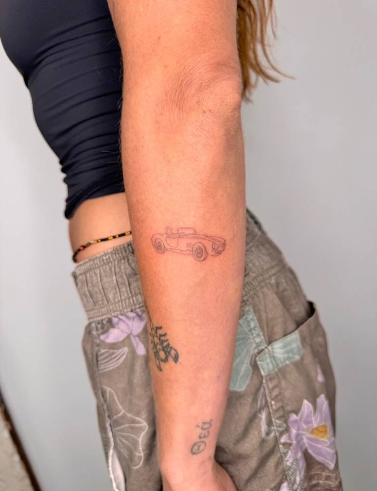 Single needle little car tattoo located on the forearm.
