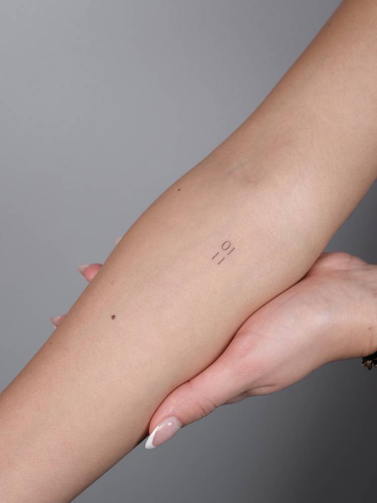 Little date tattooed on the inner forearm in serif font.