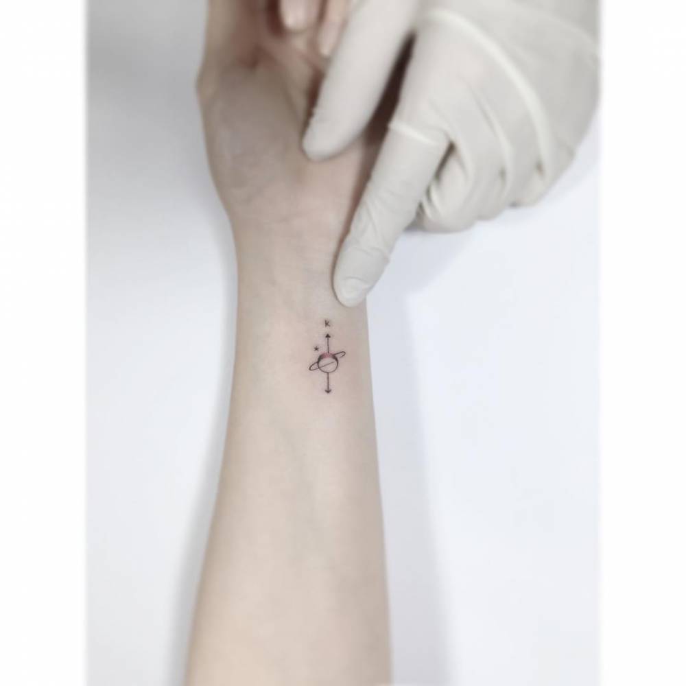 Tiny compass rose tattoo in minimalist style.