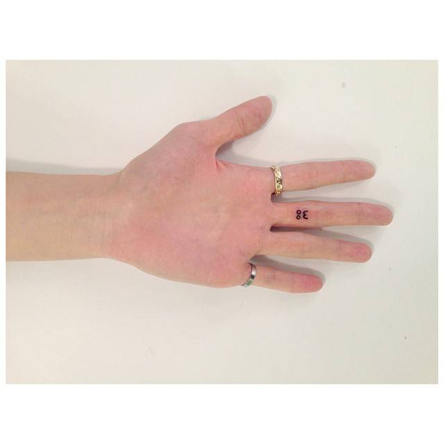 Lettering tattoo that says "woo" located on the finger.