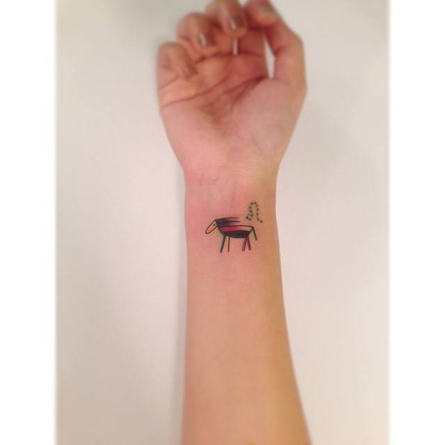 Horse tattoo in illustrative style located on the wrist.