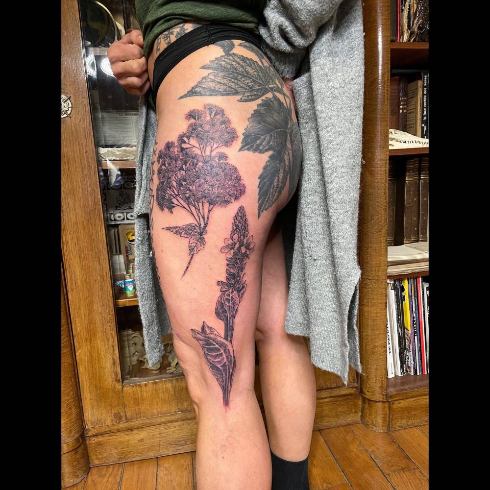 Flower bouquet and mullein tattoos located on the thigh.
