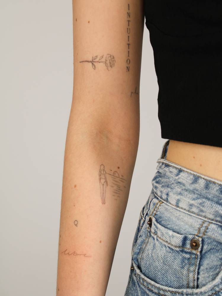 Handwritten font word "libre" tattooed on the forearm.