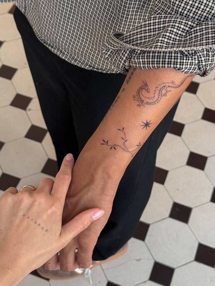 Leaves tattoo in minimalistic style located on the wrist.