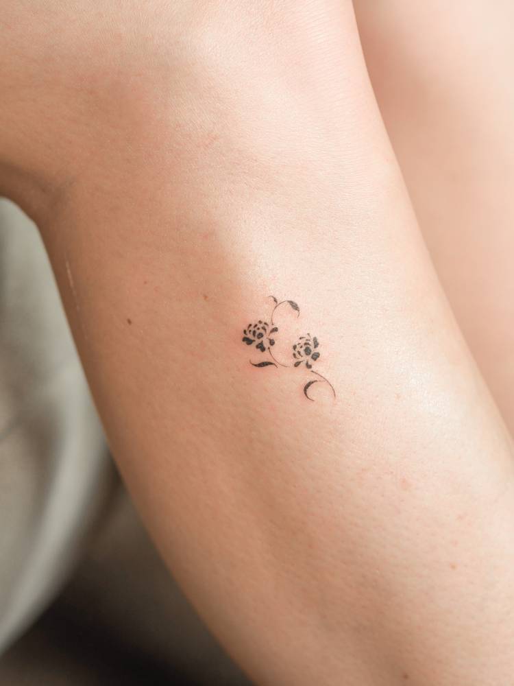 Minimalistic flowers tattoo located on the shin.