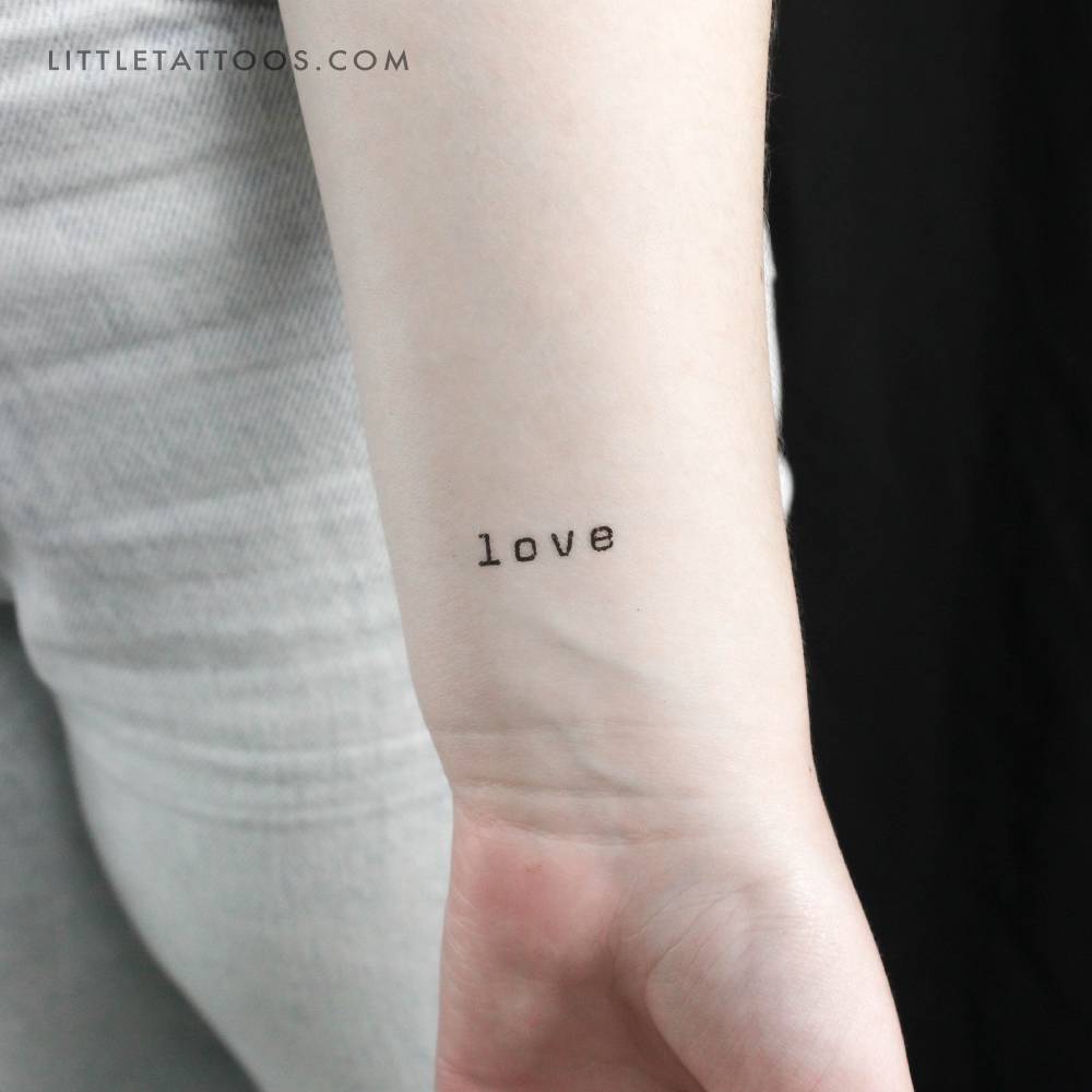 Typewriter font word 'love' temporary tattoo placed on the wrist.