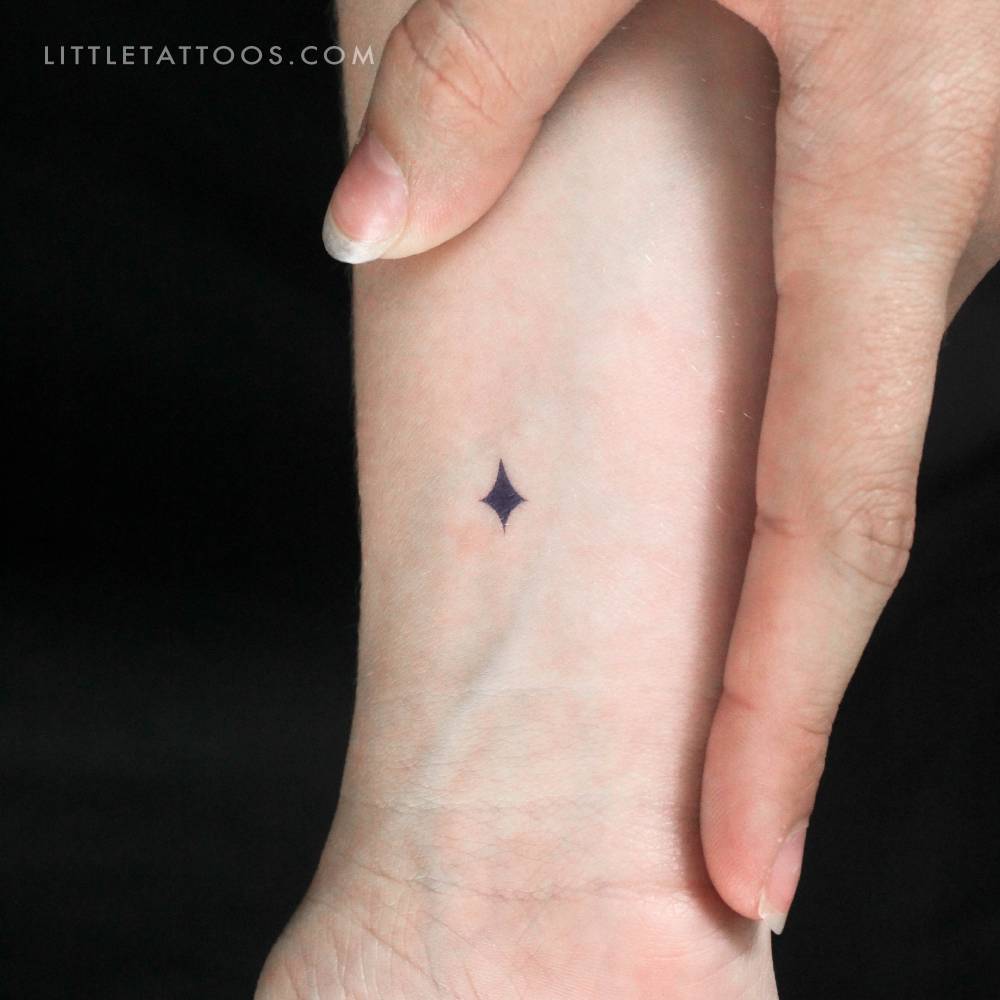 Tiny blue star temporary tattoo located on the wrist.