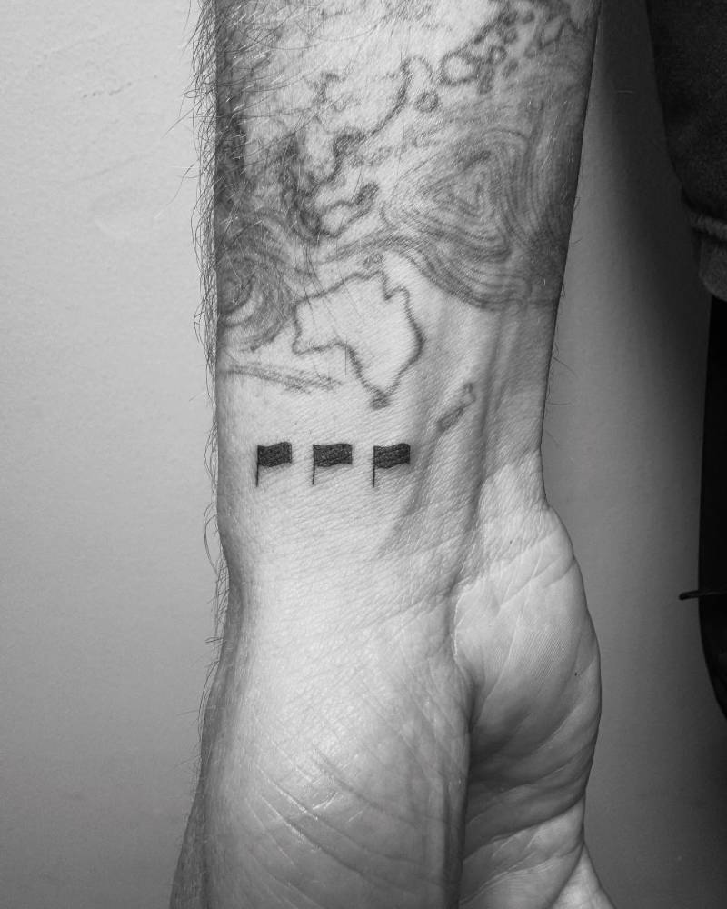 Minimalistic flags tattoo located on the wrist.