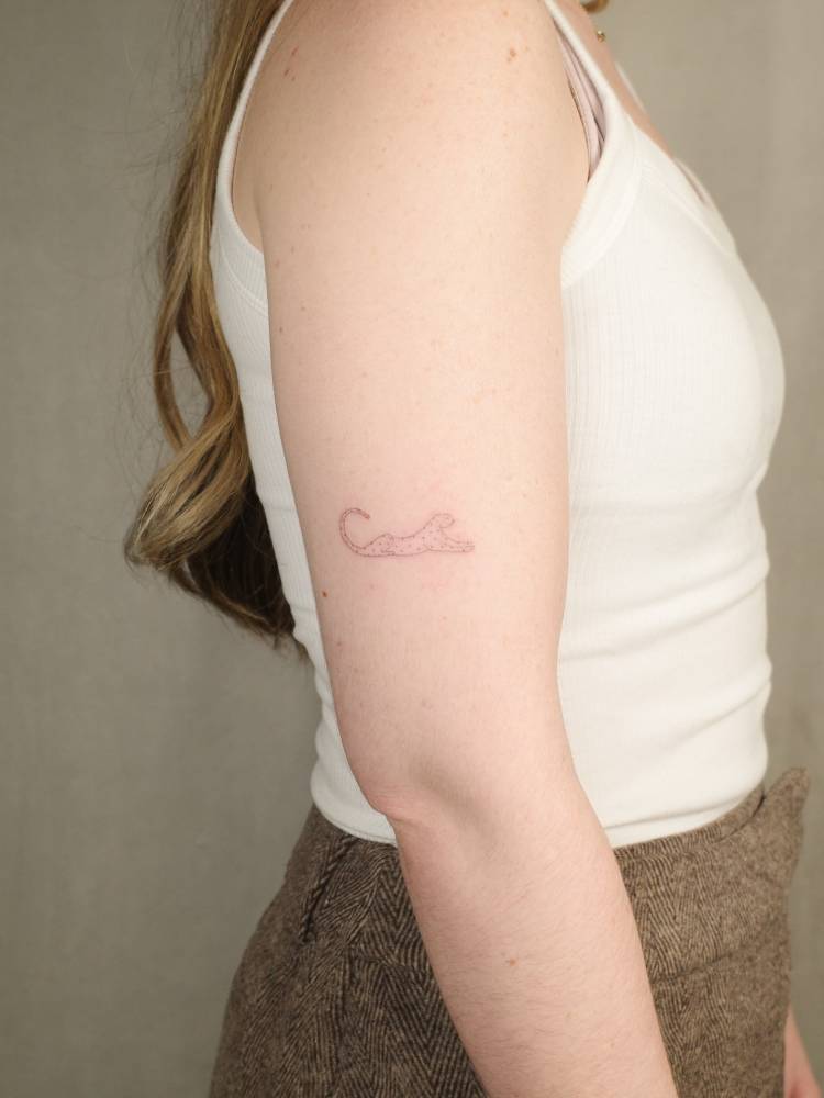 Leopard tattoo located on the upper arm, done in fine line style.
