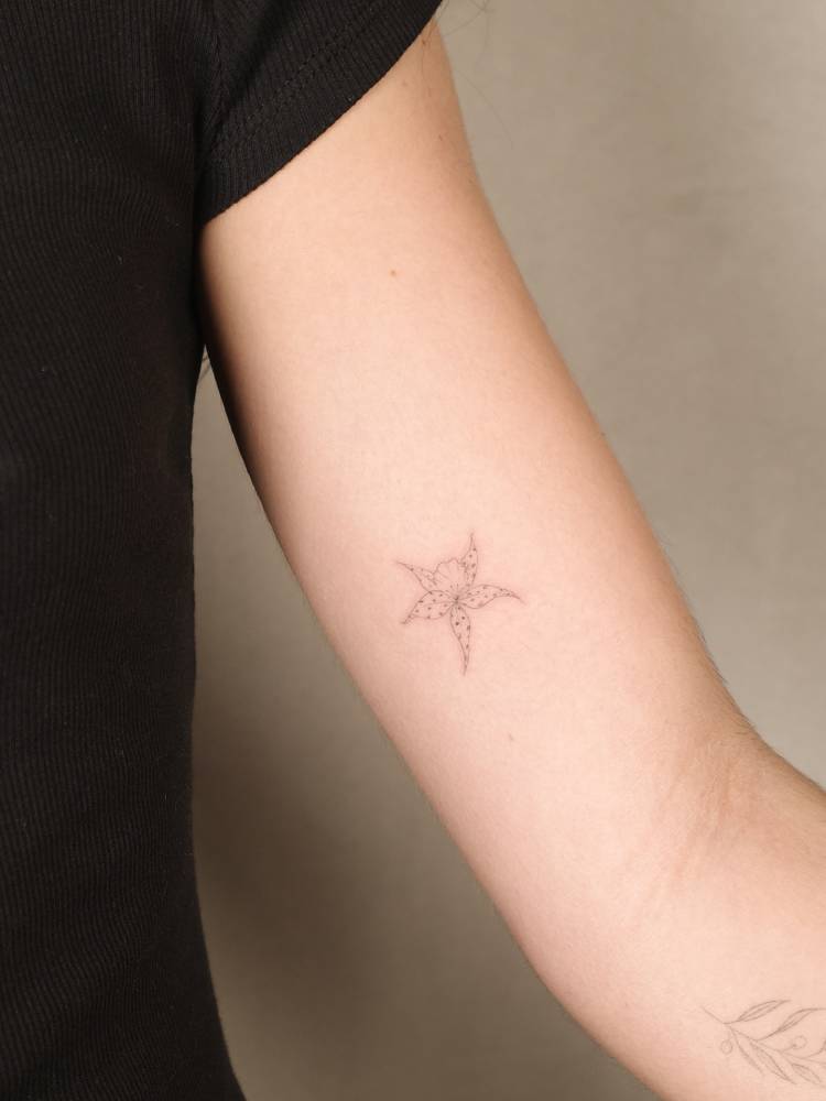 Orchid tattoo in fine line style placed on the inner arm.