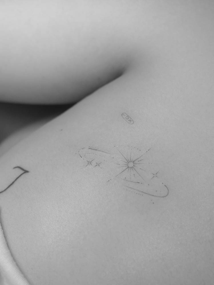 Sparkling stars tattoo located on the upper arm.